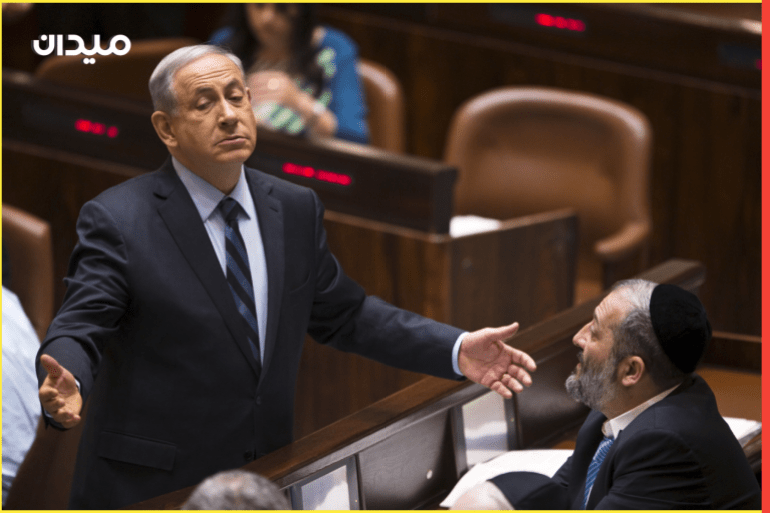Israeli Prime Minister Benjamin Netanyahu (L) gestures as he speaks to incoming minister Aryeh Deri, party leader of the Ultra-Orthodox Shas party, in the Knesset, the Israeli parliament, in Jerusalem May 13, 2015. Netanyahu's emerging government scraped by its first parliamentary test on Wednesday, paving the way for the new cabinet to be sworn in after two months of difficult coalition building. REUTERS/Ronen Zvulun TPX IMAGES OF THE DAY