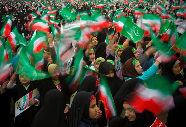 Schoolgirls wave Iranian and religious flags during a ceremony to mark the anniversary of Iran's Islamic Revolution in Tehran's Azadi (Freedom) Square February 11, 2008. REUTERS/Caren Firouz (IRAN)