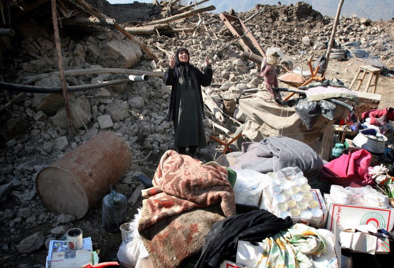 امرأة إيرانية تقف على أنقاض منزلها بعد أحد الزلازل في إيران (رويترز)