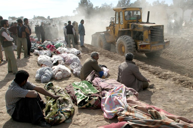 جرافة تحفر قبرا جماعيا لبعض ضحايا زلزال مدينة بام الإيرانية في العام 2003 (رويترز)