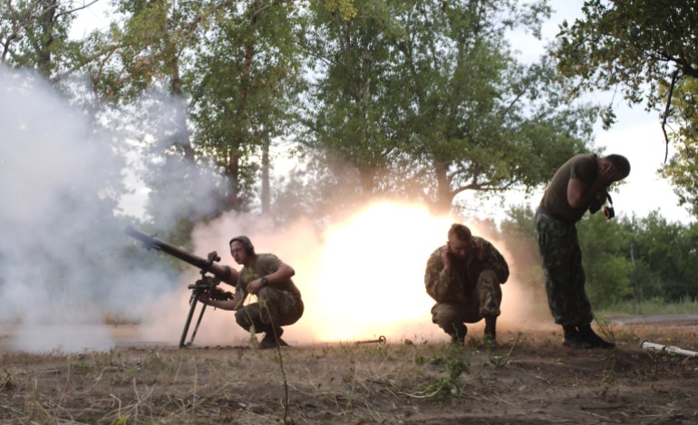 Members of the Ukrainian armed forces fire a grenade launcher in Avdiivka
