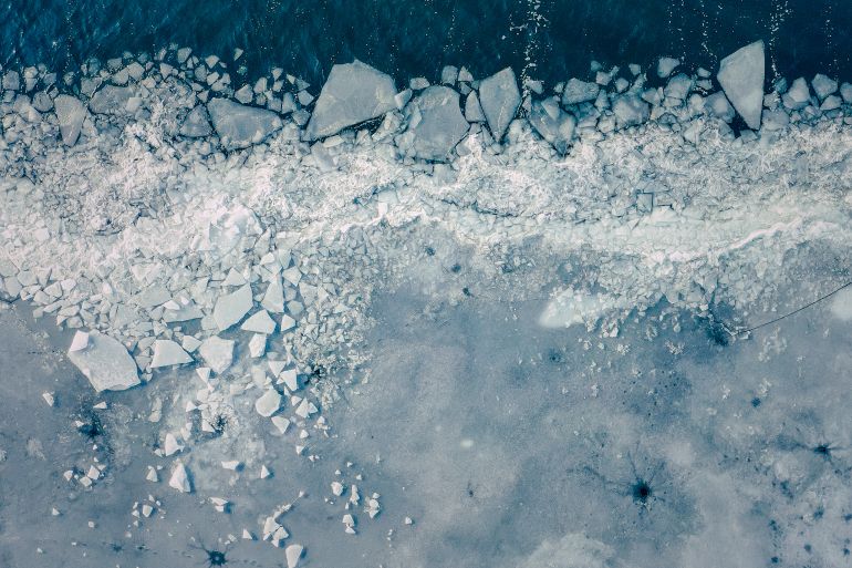 Glacier Lagoon with icebergs from above. Aerial View. Cracked Ice from drone view. Background texture concept.