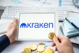 Russia Moscow 05.05.2021.Businessman holding tablet with logo of cryptocurrency stock exchange Kraken. Buy,sell,change crypto coins,diital money BTC,Bitcoin,ETH,Ethereum.Trading,investing to tokens.