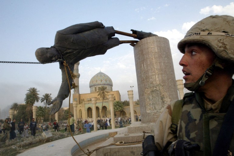FILE PHOTO: A U.S. soldier watches as a statue of Iraq's President Saddam Hussein fall in central Baghdad, Iraq April 9, 2003. REUTERS/Goran Tomasevic