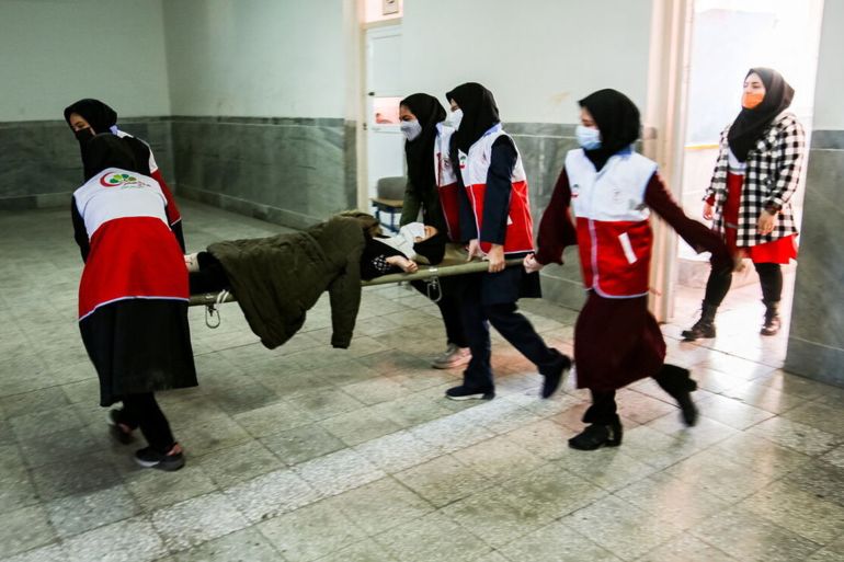 نشر موقع غسترش نيوز هذه الصورة التي تظهر موظفات الهلال الأحمر ينقلن تلميذة مصابة بالتسمم_