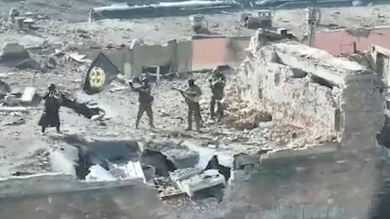 A still image taken from video released by founder of Russia's Wagner Group Yevgeny Prigozhin's press service, shows what it said to be Wagner fighters standing with a flag on top of a building in Bakhmut, Ukraine, in this still image taken from video released March 2, 2023. Press service of "Concord"/Handout via REUTERS ATTENTION EDITORS - THIS IMAGE WAS PROVIDED BY A THIRD PARTY. NO RESALES. NO ARCHIVES. MANDATORY CREDIT.