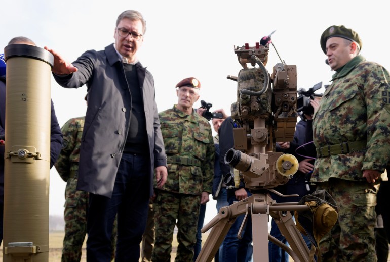 Serbia's President Aleksandar Vucic, left, inspects anti-tank Kornet guided missiles at the army barracks, some 16 kilometers (10 miles) north of Belgrade, Serbia, Monday, Jan. 3, 2022. Serbia's president on Monday praised another shipment of arms from Russia, despite fears in the Balkans that the country's recent military buildup could lead to more tensions in the war-scared region. (AP Photo/Darko Vojinovic)
