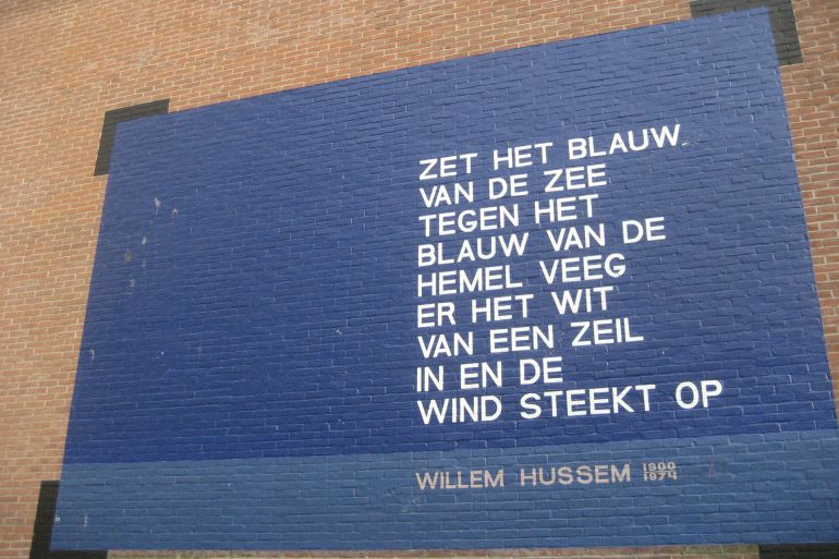 Poem by Willem Hussem on the wall of a student appartment block. Kaiserstraat, Leiden (The Netherlands) by Vysotsky (Wikimedia)