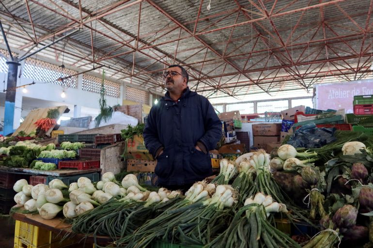 Vegetable seller Tawfik Mselmi, 53, stands at his stall at a market in Tunis