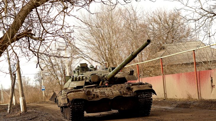 A Ukrainian serviceman gestures as he rides a tank on a road towards the frontline town of Bakhmut in Chasiv Yar
