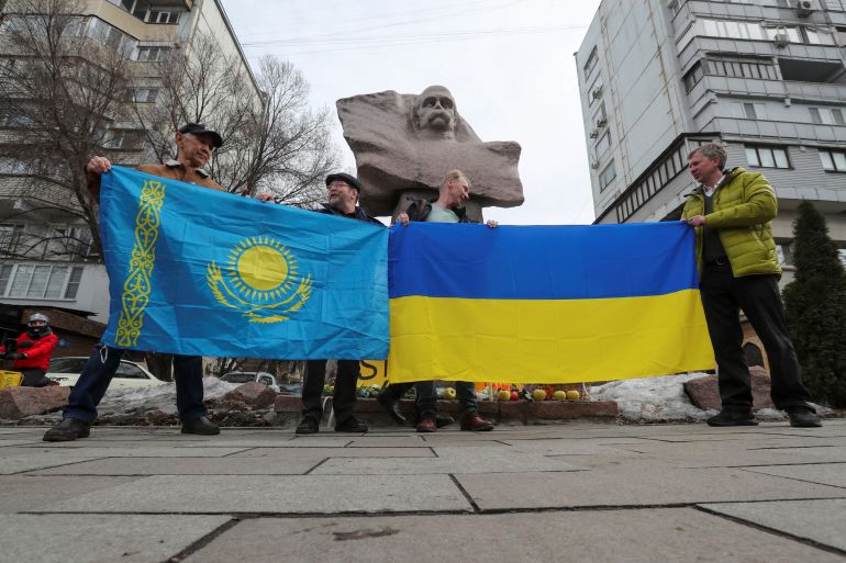 Participants hold flags during a pro-Ukrainian demonstration, which marks the first anniversary of Russia's invasion of Ukraine, near a monument to Ukrainian poet Taras Shevchenko in Almaty, Kazakhstan, February 24, 2023. REUTERS/Pavel Mikheyev