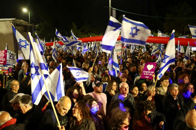 People hold Israeli flags during a demonstration as Israeli Prime Minister Benjamin Netanyahu's nationalist coalition government presses on with its contentious judicial overhaul, in Jerusalem, March 4, 2023. REUTERS/Ronen Zvulun