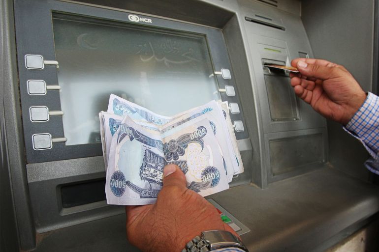 gettyimages-82400059 A user withdraws money from the Iraqi Wa A user withdraws money from the Iraqi Warka Bank ATM (automatic bank teller) in Ghelan Square in central Baghdad on August 18, 2008. This machine, one of the few working in the Iraqi capital, falls in the middle of a street market where dozens use it every day. AFP PHOTO/ALI AL-SAADI (Photo credit should read ALI AL-SAADI/AFP via Getty Images)