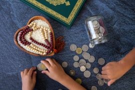 ZAKAT donation for Muslims according to religious principles during the Ramadan month, rice grain bow and rosary ,open for prayer,1443 Puasa Ramadan concept, opportunity, calligraphy, give hope