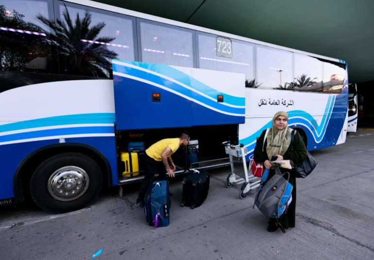 A woman stands near a bus as Iraqis and Syrians who were evacuated from Sudan by Iraqi military aircraft, arrive at Baghdad International Airport in Baghdad, Iraq April 27, 2023. REUTERS/Thaier Al-Sudani