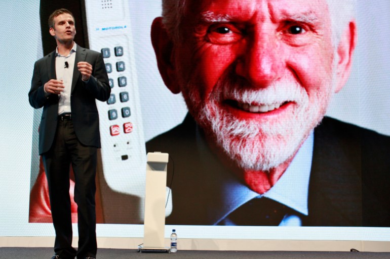 Motorola Mobility CEO Dennis Woodside speaks in front of an image of Martin Cooper, the former Motorola executive who invented the cellular phone, during a launch event in New York, September 5, 2012. REUTERS/Brendan McDermid (UNITED STATES - Tags: BUSINESS TELECOMS SCIENCE TECHNOLOGY)