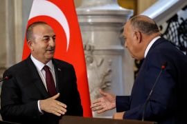 Egypt's Foreign Minister Sameh Shoukry (R) shakes hands with his Turkish counterpart Mevlut Cavusoglu, after giving a joint press conference in Cairo, on March 18, 2023. (Photo by Khaled DESOUKI / AFP)