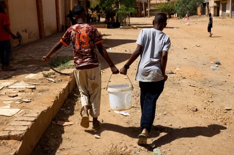 People carry water in Khartoum North