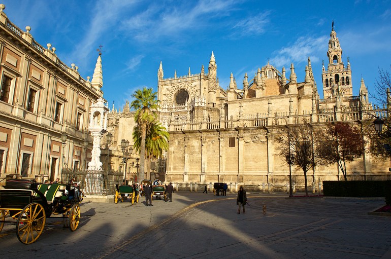 Seville,Spain-12 18 2015:The Seville Cathedral,a Gothic landmark with its Moorish style bell tower, known as The Giralda and which was originally built as the minaret for the Great Mosque of Seville