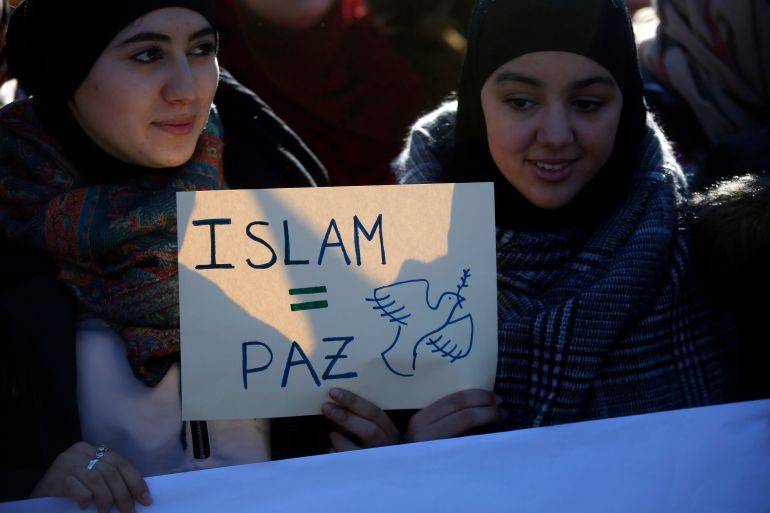 Two young women hold a placard that reads "Islam = Peace" during a rally by members of the Muslim community of Madrid outside Madrid's Atocha train station, January 11, 2015, in solidarity with the victims of a shooting by gunmen at the Paris offices of the satirical weekly newspaper Charlie Hebdo, and against Islamophobia. REUTERS/Juan Medina (SPAIN - Tags: CIVIL UNREST CRIME LAW POLITICS) ATTENTION EDITORS - SPANISH LAW REQUIRES THAT THE FACES OF MINORS ARE MASKED IN PUBLICATIONS WITHIN SPAIN