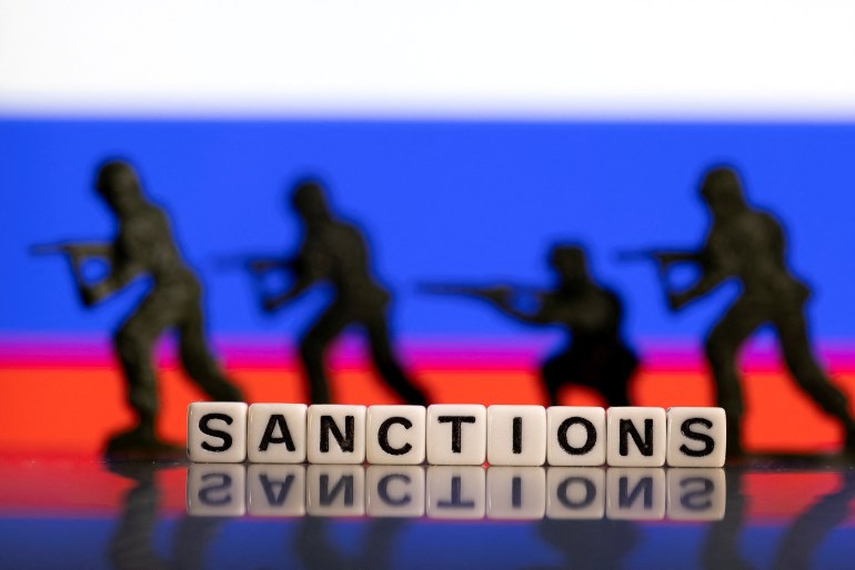 FILE PHOTO: Plastic letters arranged to read "Sanctions" and solider toys are placed in front of Russia's flag colors in this illustration taken February 25, 2022. REUTERS/Dado Ruvic/Illustration/File Photo