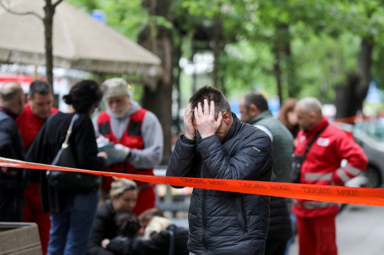 People react after a 14-year-old boy opened fire on other students and security guards at a school in downtown Belgrade