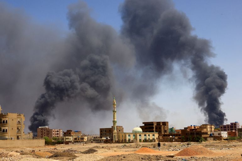 A man walks while smoke rises above buildings after aerial bombardment, during clashes between the paramilitary Rapid Support Forces and the army in Khartoum North, Sudan, May 1, 2023. REUTERS/Mohamed Nureldin Abdallah TPX IMAGES OF THE DAY