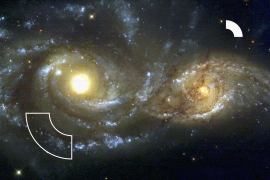 IN THE DIRECTION OF THE CONSTELLATION CANIS MAJOR, TWO SPIRAL GALAXIES PASS BY EACH OTHER. THE NEAR-COLLISION HAS BEEN CAUGHT IN IMAGES TAKEN BY NASA'S HUBBLE SPACE TELESCOPE AND ITS WIDE FIELD PLANETARY CAMERA 2.