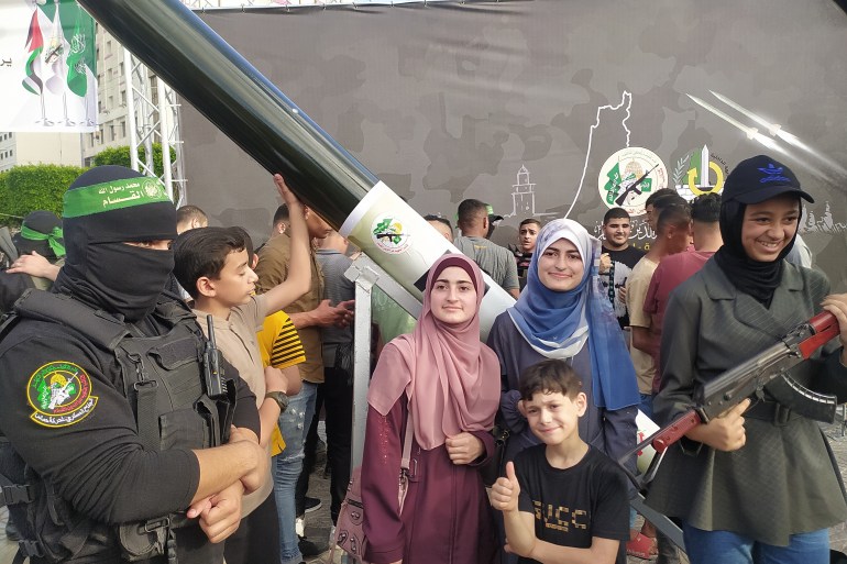 أسرة تلتقط صورة مع صاروخ لكتائب القسام مصنع محلياً في غزة-رائد موسى-الجزيرة نت