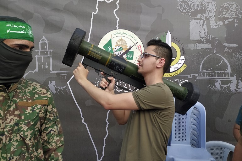 شاب يستعرض أحد الأسلحة القسامية في فعالية المقاومة صورة وتذكار في غزة-رائد موسى-الجزيرة نت