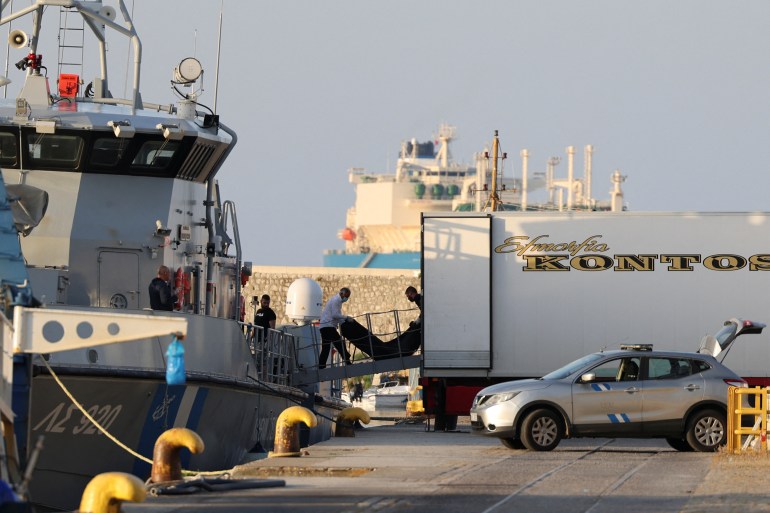 Men transfer body bags carrying migrants who died after their boat capsized in the open sea off Greece, onboard a Hellenic Coast Guard vessel at the port of Kalamata, Greece, June 15, 2023. REUTERS/Stelios Misinas