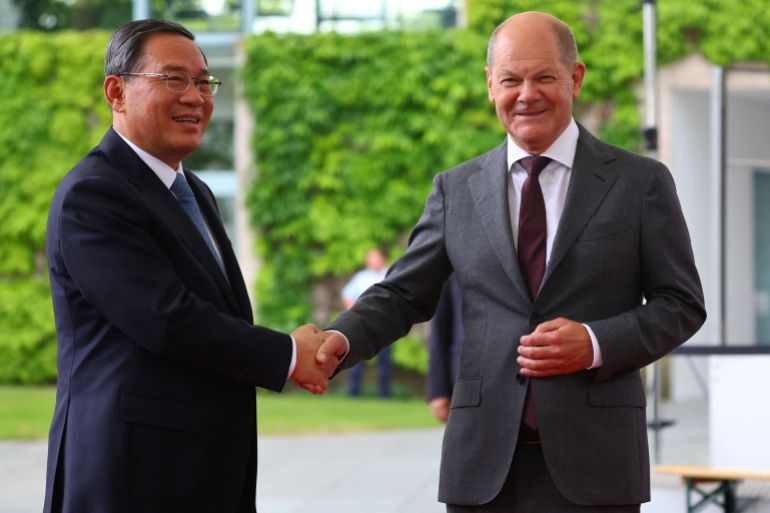 المستشار الألماني شولتز (يمين) يستقبل رئيس الوزراء الصيني لي تشيانغ في برلين (رويترز)