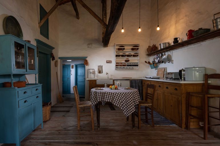 Traditional interior of old village kitchen in historic country house with stucco walls, wooden beams, oak wood furniture, vintage kitchenware; Shutterstock ID 1910630515; purchase_order: aljazeera ; job: ; client: ; other: