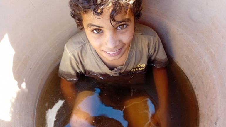 فاطمة محمود الأغوار الشمالية الجزيرة نت،طفل من خربة مكحول يجلس في الماء للتخفيف من حرارة الجو في الأغوار