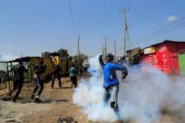 A protestor hurls a tear gas canister as supporters of Kenya's opposition leader Raila Odinga of the Azimio La Umoja (Declaration of Unity) One Kenya Alliance, participate in an anti-government protest against the imposition of tax hikes by the government in Nairobi, Kenya July 21