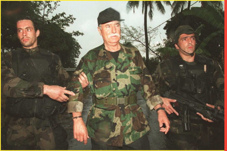 Legendary French mercenary Bob Denard (center left) is led away from the Kandami Army Barracks October 5 by French Special Forces during a tropical downpour. Denard, who organized last weeks coup in the Comoros, negotiated the surrender of himself, 27 white mercenaries and some 300 rebel Comorian soldiers