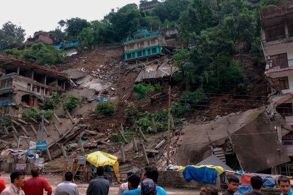 People look on after several buildings that had recently developed cracks and were evacuated, collapsed following heavy rains in Anni, Kullu district, Himachal Pradesh, India, Thursday, Aug.24, 2023. No casualties were reported. (AP Photo)