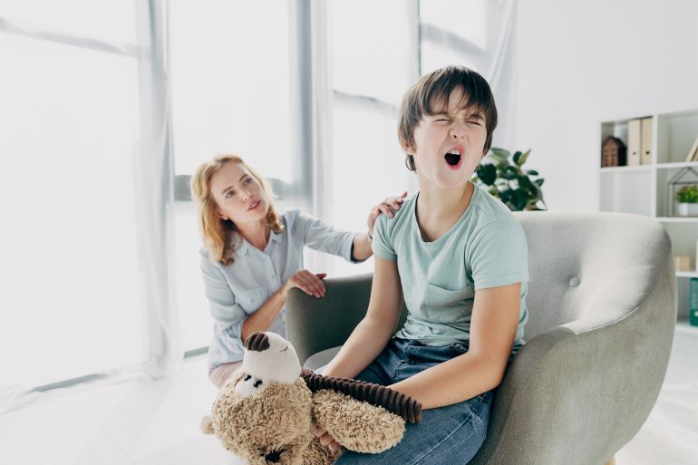 Kid with dyslexia screaming and child psychologist looking at him - stock photo kid with dyslexia screaming and child psychologist looking at him