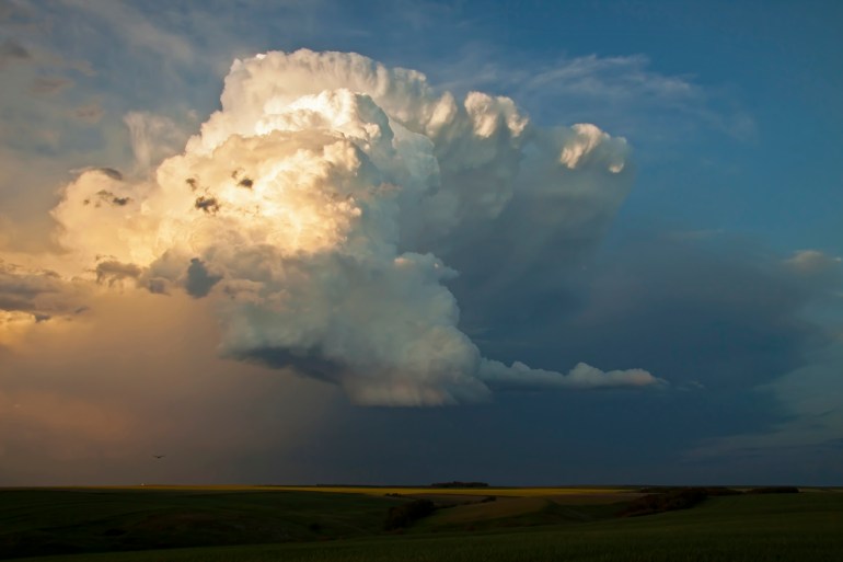Storm cloud over a rural landscape and eagle silhouette to the low left.