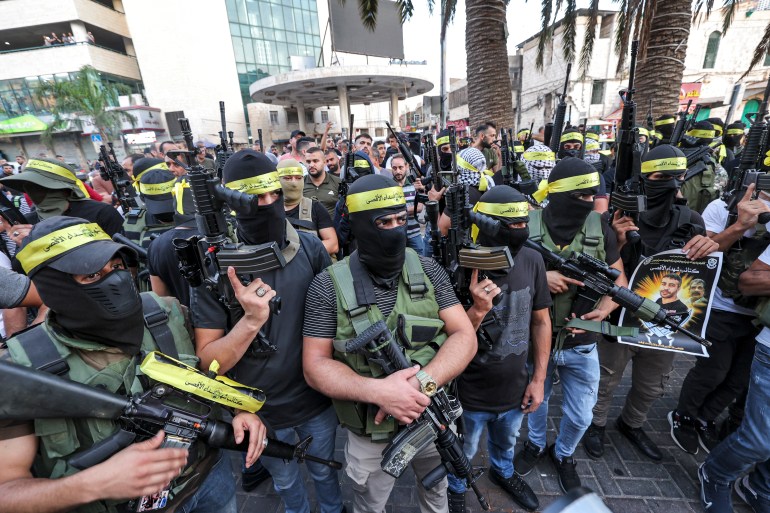 Masked militants of the Palestinian Fatah movement's "Aqsa Martyrs Brigades" armed faction march in centre of the city of Nablus in the occupied West Bank on September 10, 2022, after a rally demanding the release of Nasser Abu Hamid, a Palestinian prisoner held by Israel who suffers from cancer. (Photo by JAAFAR ASHTIYEH / AFP)