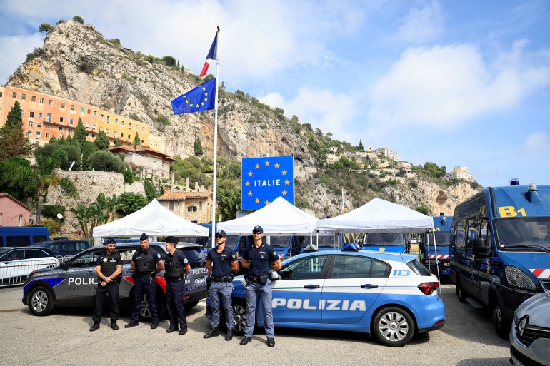 French and Italian police officers stand guard during the visit of French interior minister at Menton's border post on September 12, 2023. (Photo by Valery HACHE / AFP)