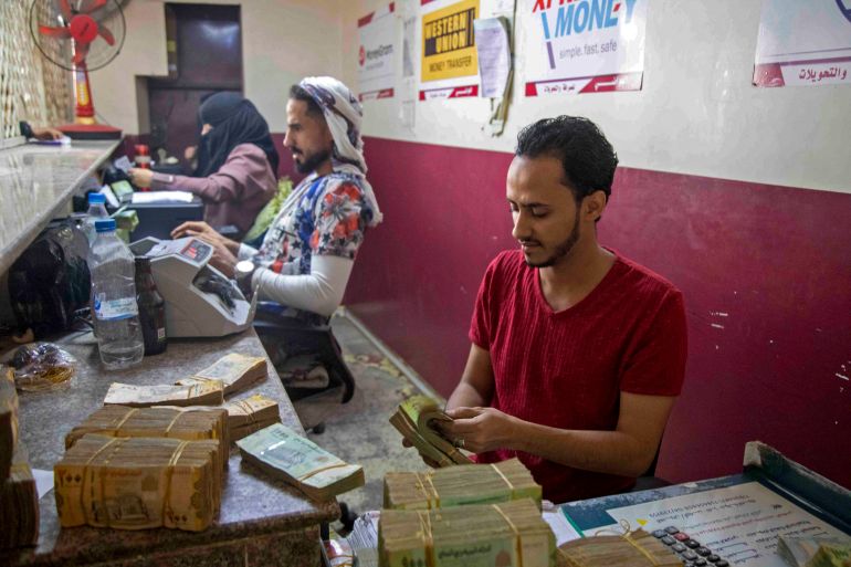 Employees count banknotes at a currency exchange office in Yemen's third city of Taez on November 4, 2021, amid deteriorating economic and living conditions due to the prolonged state of conflict. (Photo by AHMAD AL-BASHA / AFP)