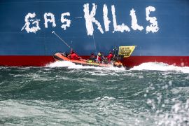 نشطاء بيئة يرفعون شعار &#34;الغاز يقتل&#34; قرب محطة للغاز الطبيعي المسال من المقرر أن تديرها شركة توتال إنيرجي في ميناء لوهافر بفرنسا (غرين بيس لرويترز)