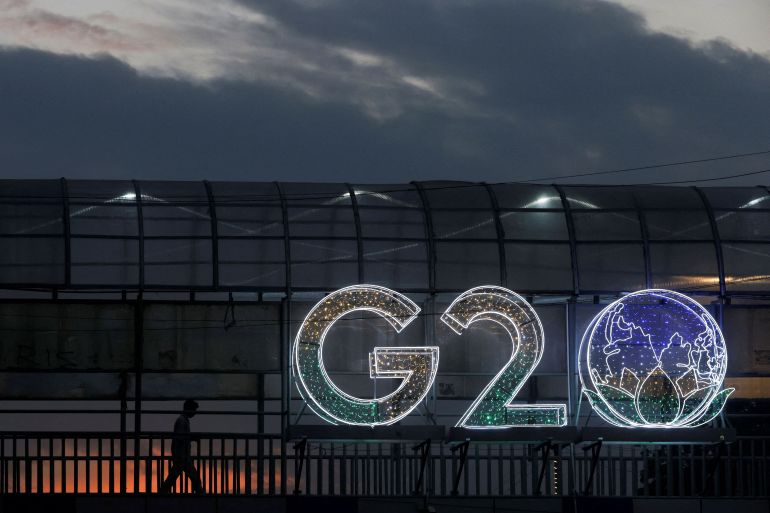 A man walks past an installation on a skywalk ahead of the G20 Summit in New Delhi