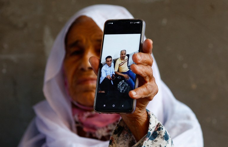 A Palestinian Woman from Abu Amra family shows a picture of her relatives who fled from Gaza to Libya as impoverished refugees during the 1967 Middle East war and were among the people who were a victim of floods in Libya, in Deir Al-Balah, central Gaza Strip September 13, 2023. REUTERS/Ibraheem Abu Mustafa