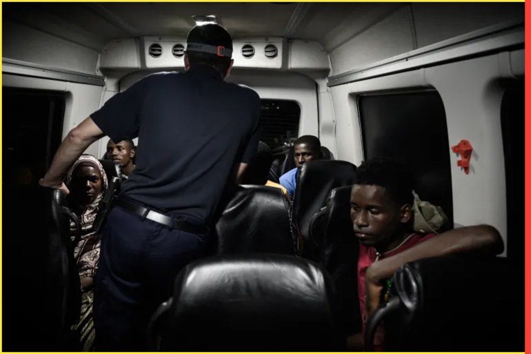 This photo taken on late May 24, 2023 shows a French police officer questioning illegal immigrants in Mayotte after they were intercepted as they were sailing clandestinely at night from Comoros to the French Indian Ocean island of Mayotte. Authorities in Mayotte are carrying out Operation Wuambushu "Take Back" in the local language, to clear slums, including by razing makeshift settlements, and send illegal migrants back to the neighbouring Comoros. (Photo by Philippe LOPEZ / AFP)