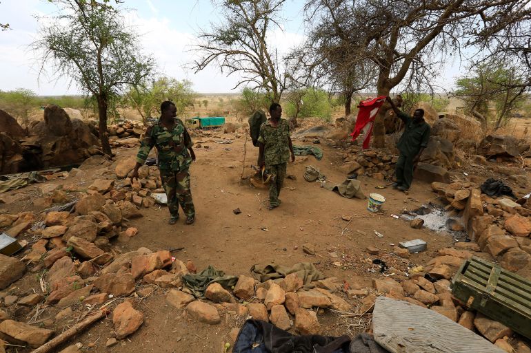 Sudanese Armed Forces (SAF) and the Rapid Support Forces (RSF) personnel examine belongings of rebels, after recapturing the Daldako area, east of Kadogli May 20, 2014. The SAF had recaptured the Daldako area, east of the South Kordofan state capital of Kadogli, from rebels, according to media reports quoting the SAF on Sunday. REUTERS/Mohamed Nureldin Abdallah (SUDAN - Tags: POLITICS CIVIL UNREST)