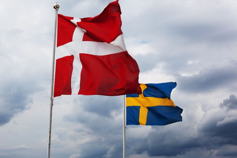 The Danish and Swedish flag waving in the wind