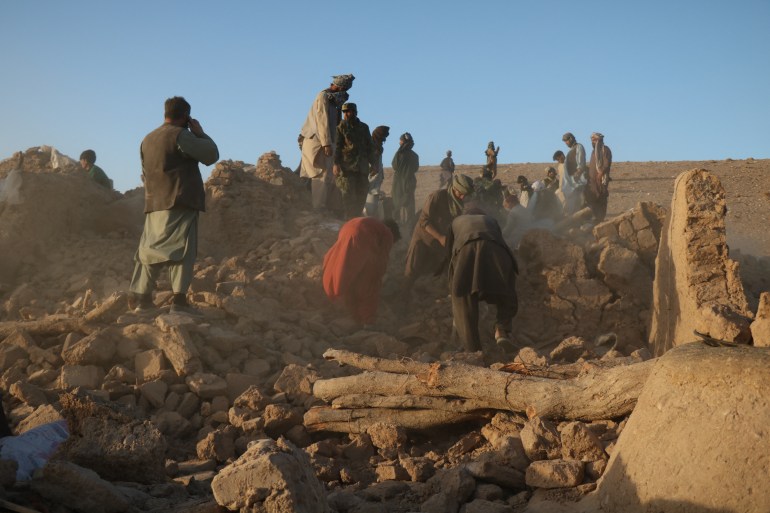 Afghan residents clear debris from a damaged house after earthquake in Sarbuland village of Zendeh Jan district of Herat province on October 7,2023 (Photo by Mohsen KARIMI / AFP)