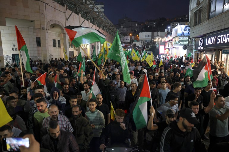 Supporters of the Fatah and Hamas movments lift group and Palestinian flags as they march in Hebron city in the occupied West Bank on October 11, 2023, to protest the Israeli bombardment of the Gaza Strip. - Israel kept up its bombardment of Hamas targets in the Gaza Strip on October 11, as Prime Minister Benjamin Netanyahu and a political rival announced an emergency government for the duration of the conflict that has killed thousands. (Photo by HAZEM BADER / AFP)